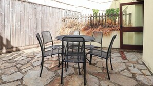 A patio with a stone floor, a wooden fence, and a table with chairs. - IRIS AT STANCOMBE MANOR, pet friendly, with pool in Chillington (Kingsbridge)
