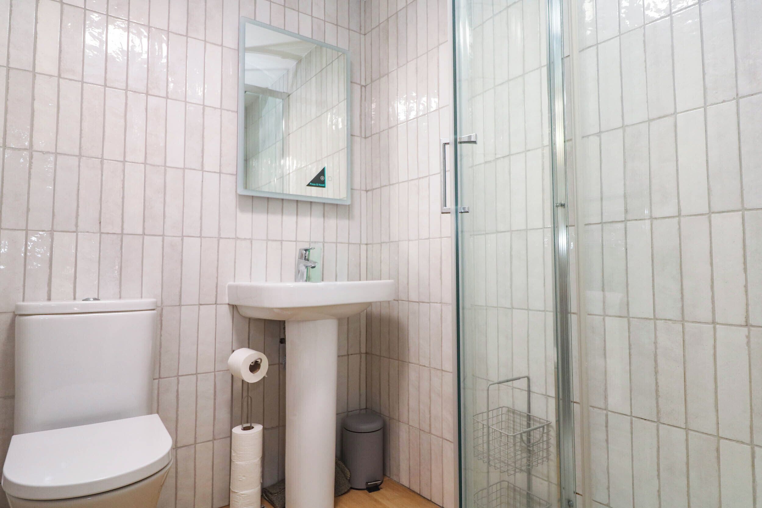 A bathroom with a toilet, sink, and glass-enclosed shower.