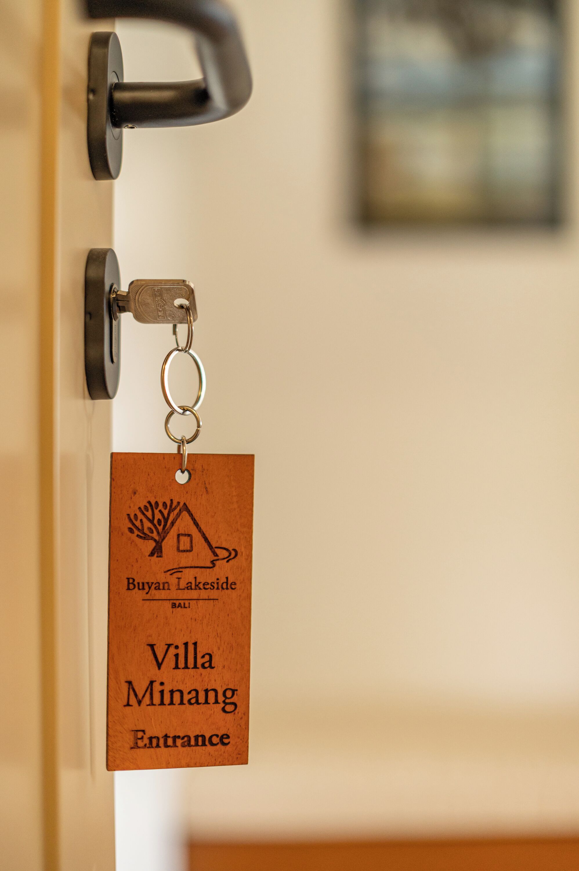 Un llavero con una etiqueta de madera colgando del picaporte, señalando la entrada a Villa Minang.