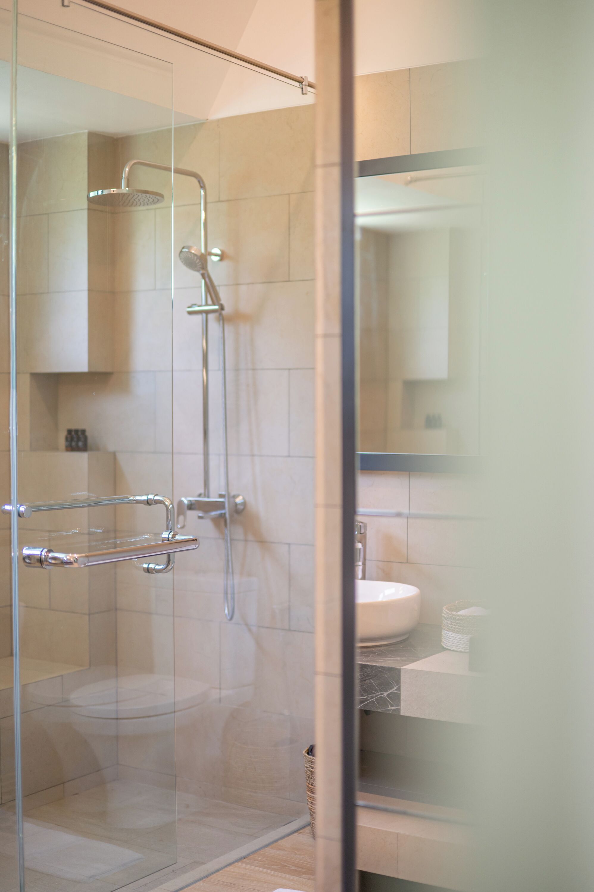 Ein modernes Badezimmer mit Duschabtrennung aus Glas, Toilette und Waschbecken.