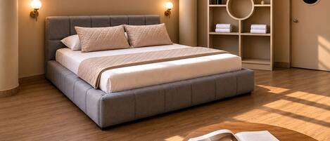 A modern bedroom with a large bed, bedside lamps, a round table with a book and cup, and a wardrobe with shelves.