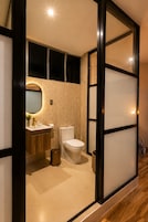 Un baño moderno con inodoro, lavabo y espejo.