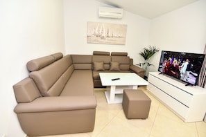 A modern living room with a sectional sofa, a coffee table, and a TV.