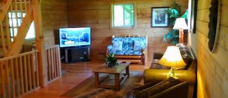 Un intérieur en bois avec un téléviseur, un canapé et une table.
