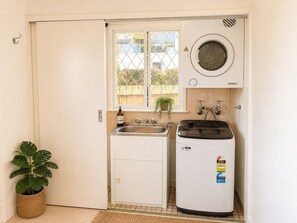 Cuina compacta amb rentadora integrada, un rentaplat i una finestra amb vista exterior.