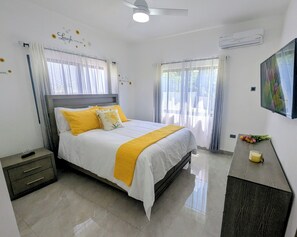 A hotel room with a bed, bedside table, and a TV.