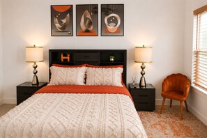 A bedroom with a bed, two bedside tables with lamps, a chair, and three abstract paintings on the wall. - Luxury 1BR Private Suite • Private Entry • Houston Getaway (Houston)
