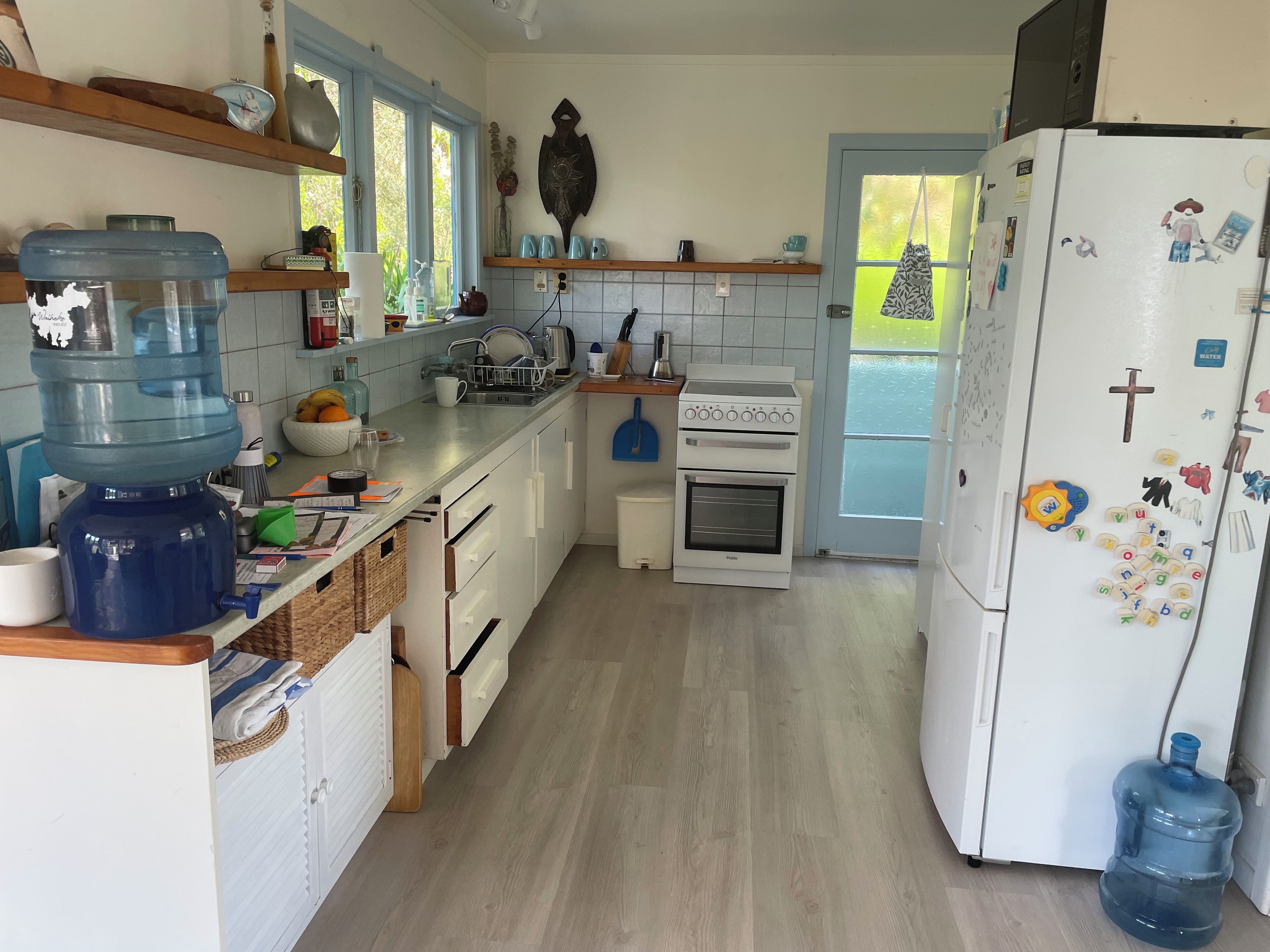 Une cuisine équipée d’un distributeur d’eau, d’une cuisinière et d’un réfrigérateur.