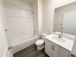 A bathroom with a bathtub, toilet, and sink.