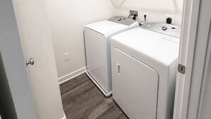 A laundry room with two white washing machines, a drying rack, and a small window. - Spacious 5BR Upper Home Near DC, National Harbor & Joint Base Andrews (Waldorf)