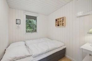 A small, single-bed room with white walls and a sloped ceiling. - Cozy holiday home in Hune near Blokhus (Hune)