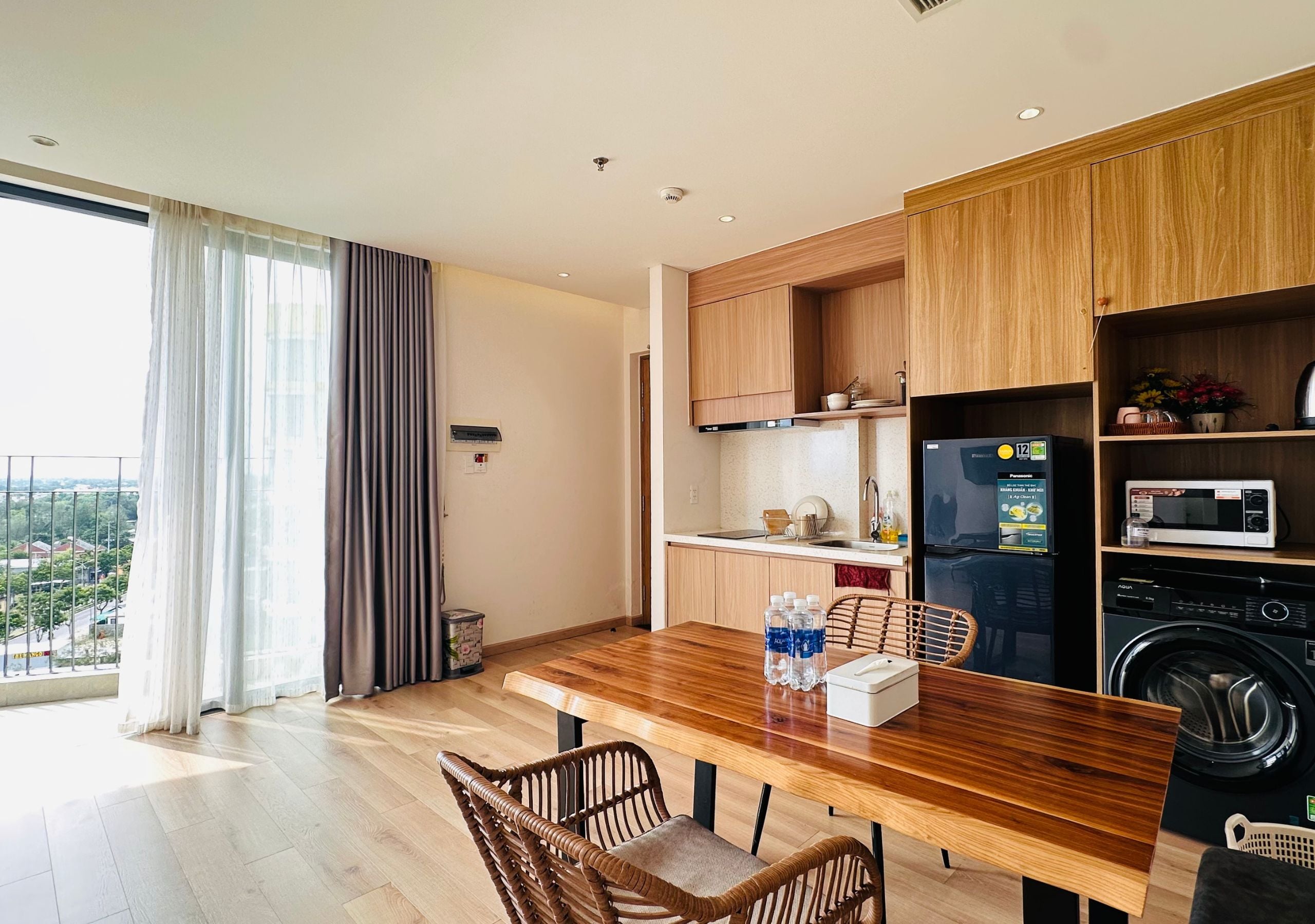 A modern kitchen with wooden cabinets, a built-in microwave, and a washing machine.