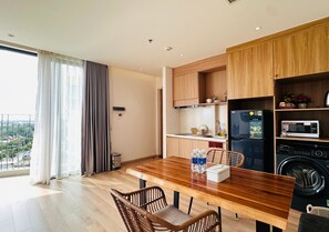 Une cuisine moderne avec des meubles en bois, un four à micro-ondes encastré et un lave-linge.