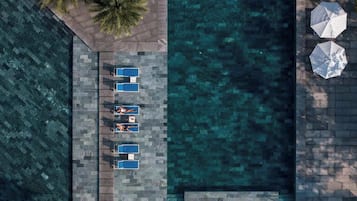 An aerial view of a pool area with lounge chairs and umbrellas.