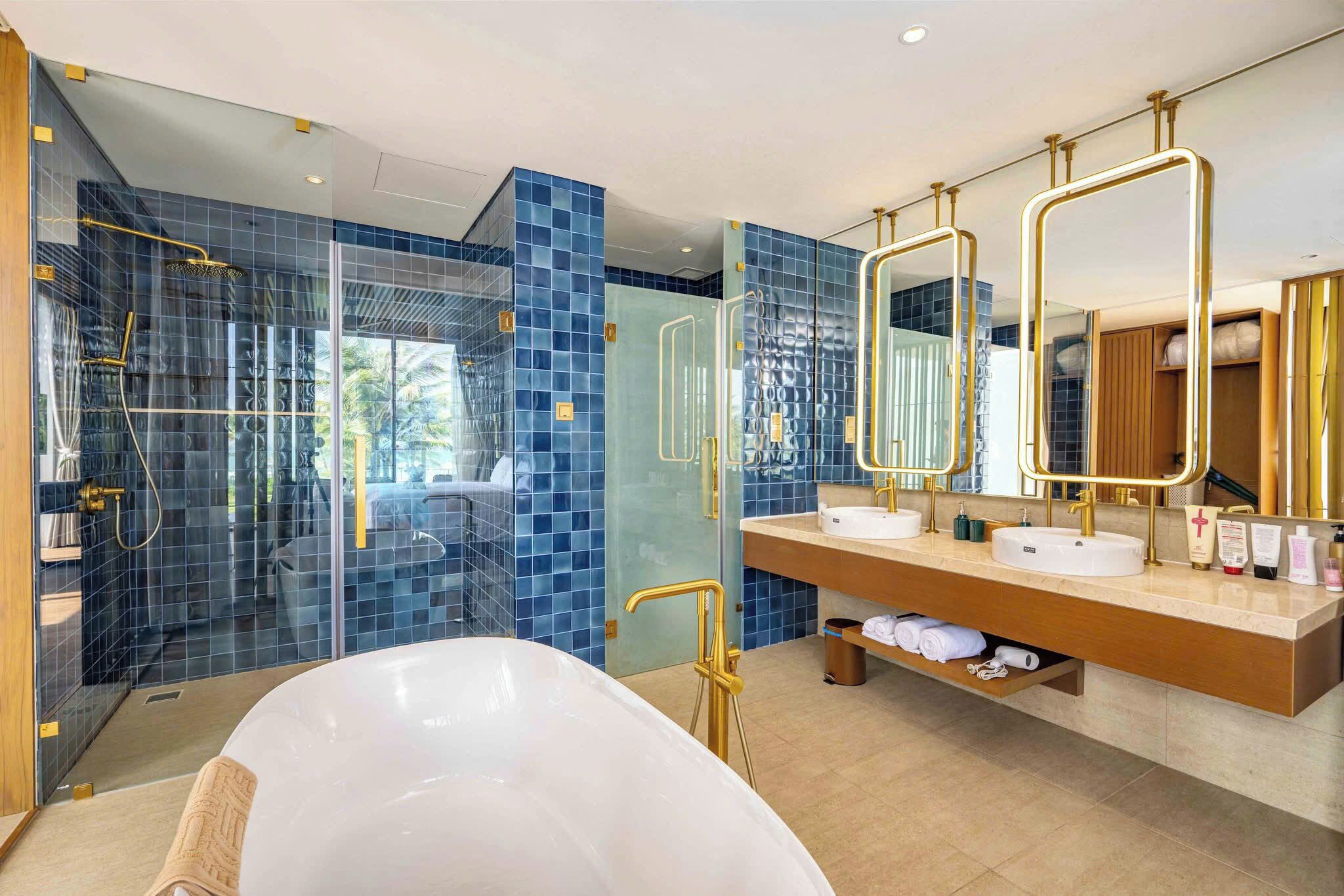 Un baño moderno con una bañera grande, lavamanos dobles y cabina de ducha a ras de suelo.