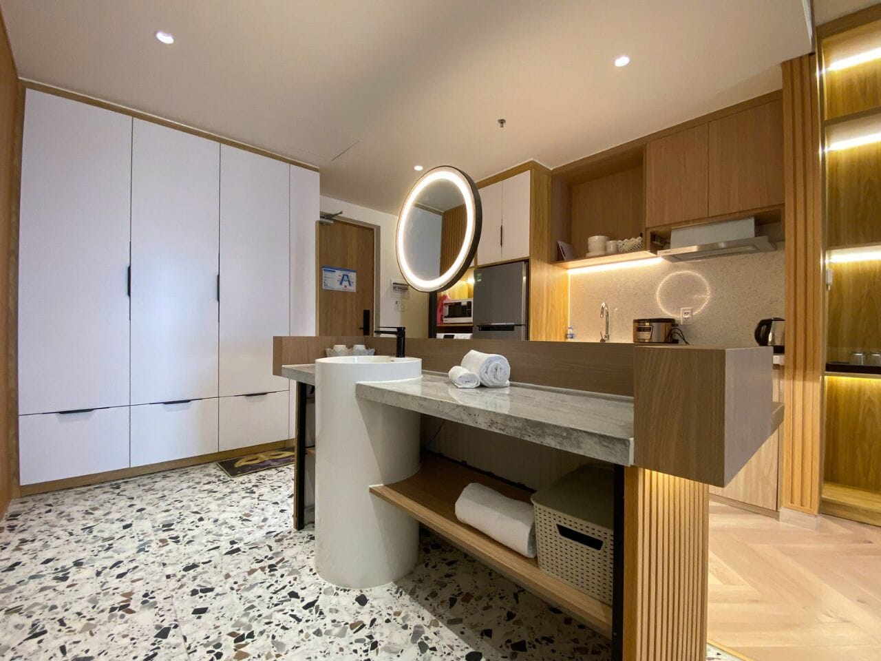 Un baño moderno con un lavamanos independiente, un espejo y un perchero para toallas.