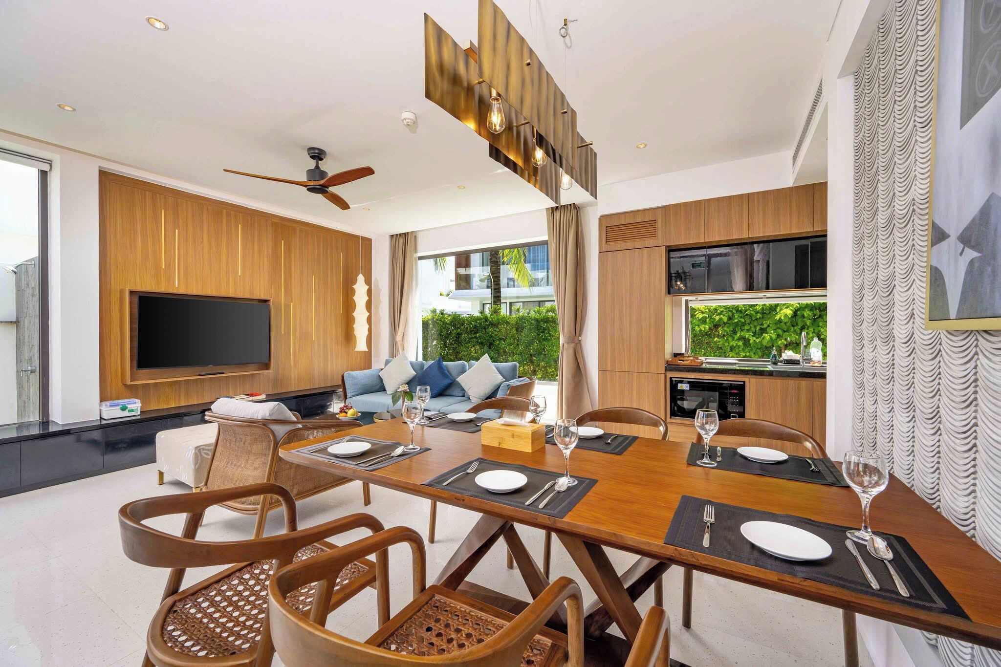 Un espace repas moderne avec une table en bois dressée pour six personnes, entourée de chaises en osier.