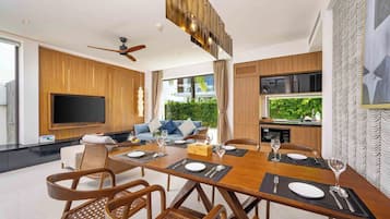 Un espace repas moderne avec une table en bois dressée pour six personnes, entourée de chaises en osier.