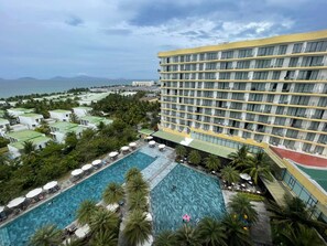 Un hotel de varios pisos, una piscina y vistas al mar.