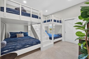 Ein Zimmer mit Etagenbetten, einer Treppe und einer Tür.