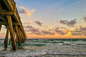 A pier extending into the ocean with waves crashing against it. - Short Drive to Beach | Pool Table + Fenced Yard (Navarre)