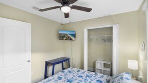 A bedroom with a bed, a desk, a closet, and a ceiling fan. - Sunshine & Shenanigans | Navarre | 5 Min to Beach (Navarre)