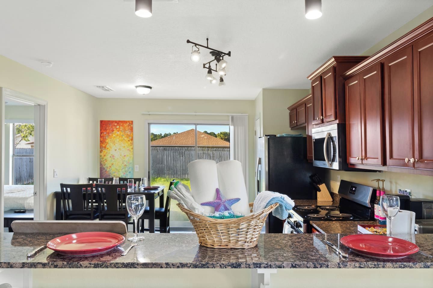 A modern kitchen with granite countertops, stainless steel appliances, and wooden cabinets.