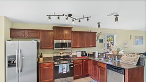 A modern kitchen with stainless steel appliances, wooden cabinets, and a farmhouse sink. - Sunshine & Shenanigans | Navarre | 5 Min to Beach (Navarre)