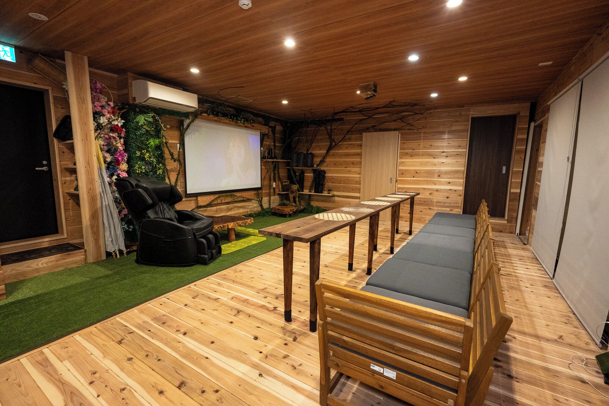 Un intérieur en bois comprenant un fauteuil de massage, une table et un banc.