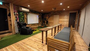 A wooden interior with a massage chair, a table, and a bench.