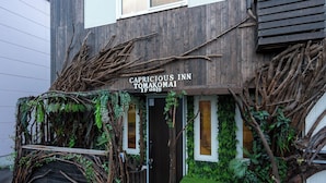 Puinen rakennus, jonka yläpuolella on kyltti, jossa lukee: ”Capricious Inn Tomakomai”.
