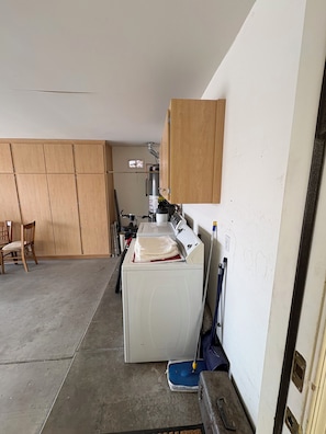 A laundry room with a washing machine, a drying rack, and a mop. - 2-bedroom house in Active Adult Golf Course Community in Chandler (Chandler)