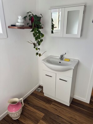 Chuveiro, toalhas de banho, sabonete, papel higiênico