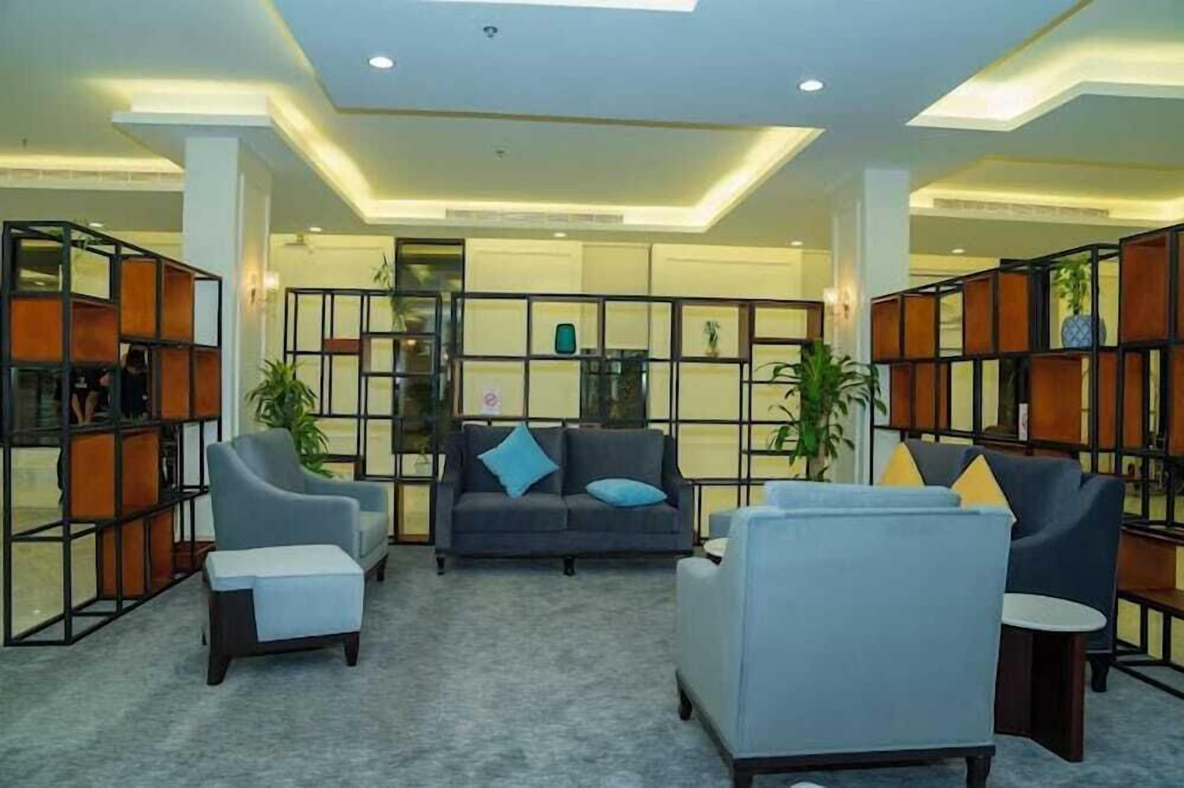A lobby with seating arrangements, a reception desk, and a decorative wall.