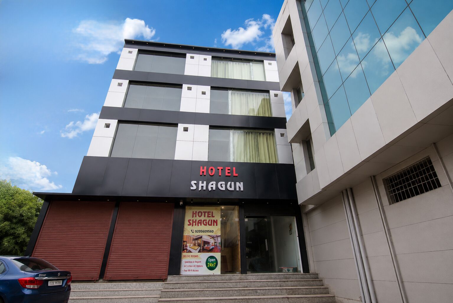 Un hotel con una fachada moderna, una entrada visible y un letrero que anuncia habitaciones de lujo.