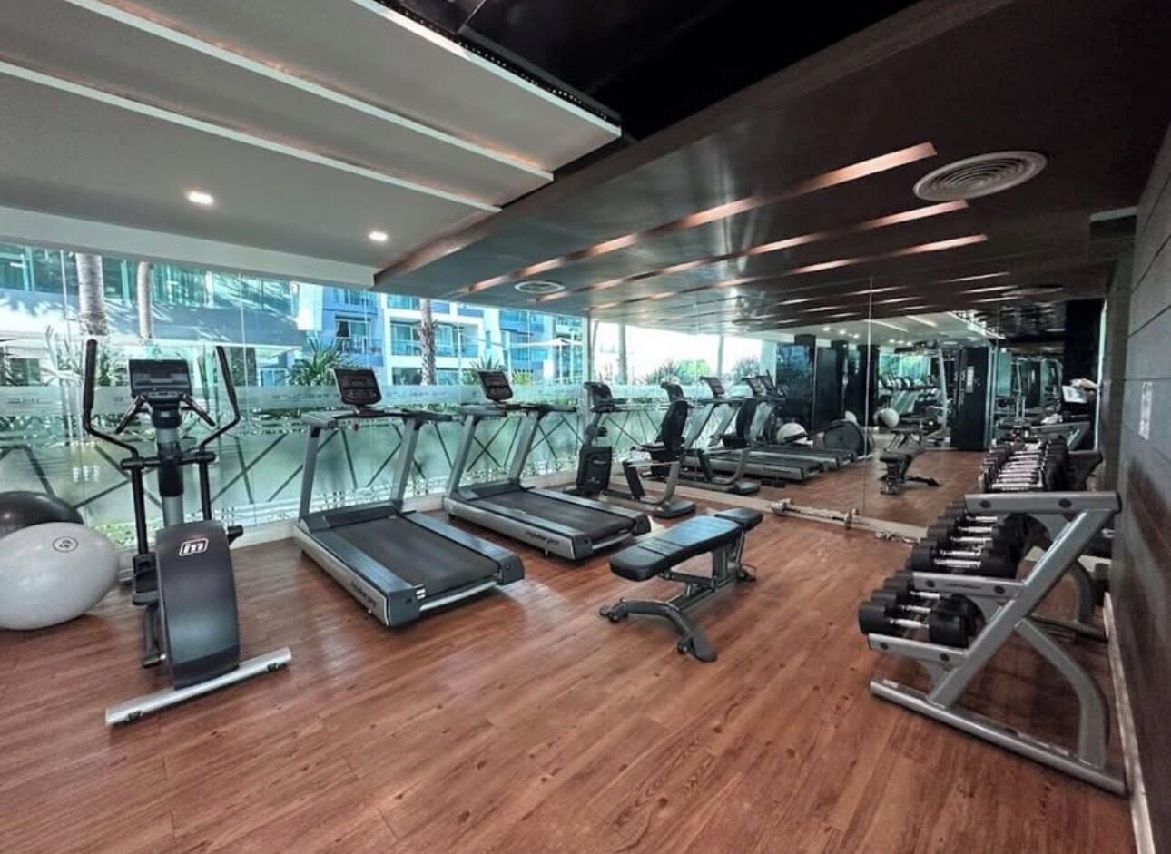 Un gimnasio con cintas de correr, elípticas y bancos de pesas.