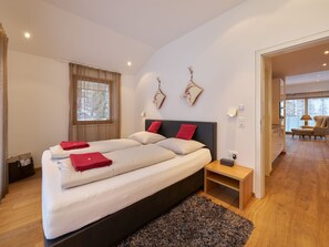 A modern bedroom with a large bed, bedside tables, and a view of the outdoors. - Apartments Grischuna Mountain Lodge, (Samnaun-Dorf) by Interhome (Samnaun)