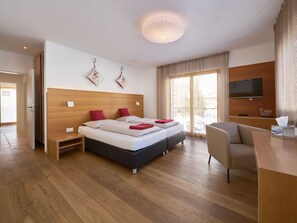 A hotel room with a large bed, a desk, a TV, and a balcony with a view. - Apartments Grischuna Mountain Lodge, (Samnaun-Dorf) by Interhome (Samnaun)