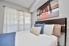 A bed with a headboard, a painting of a sunset over a pier, and sheer curtains. - 2Bedrooms 3 Beds apartment in soothing Med Center Houston with Pool and Gym (Houston)