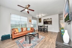 Un salon avec un canapé, une table basse et un ventilateur de plafond.