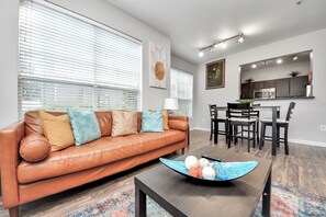A modern living room with a leather sofa, dining table, and kitchen area. - 2Bedrooms 3 Beds apartment in soothing Med Center Houston with Pool and Gym (Houston)