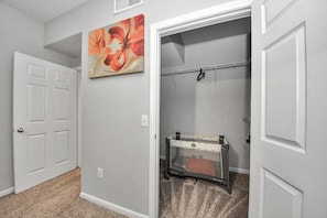 Un couloir avec une barrière de sécurité pour bébé, une porte et un tableau accroché au mur.