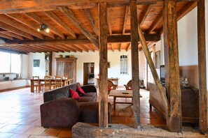 A spacious room with a high wooden ceiling, a dining area with wooden furniture, and a large window. - Charming estate for 14 people with a pool, lake, and private grounds (Arrosès)