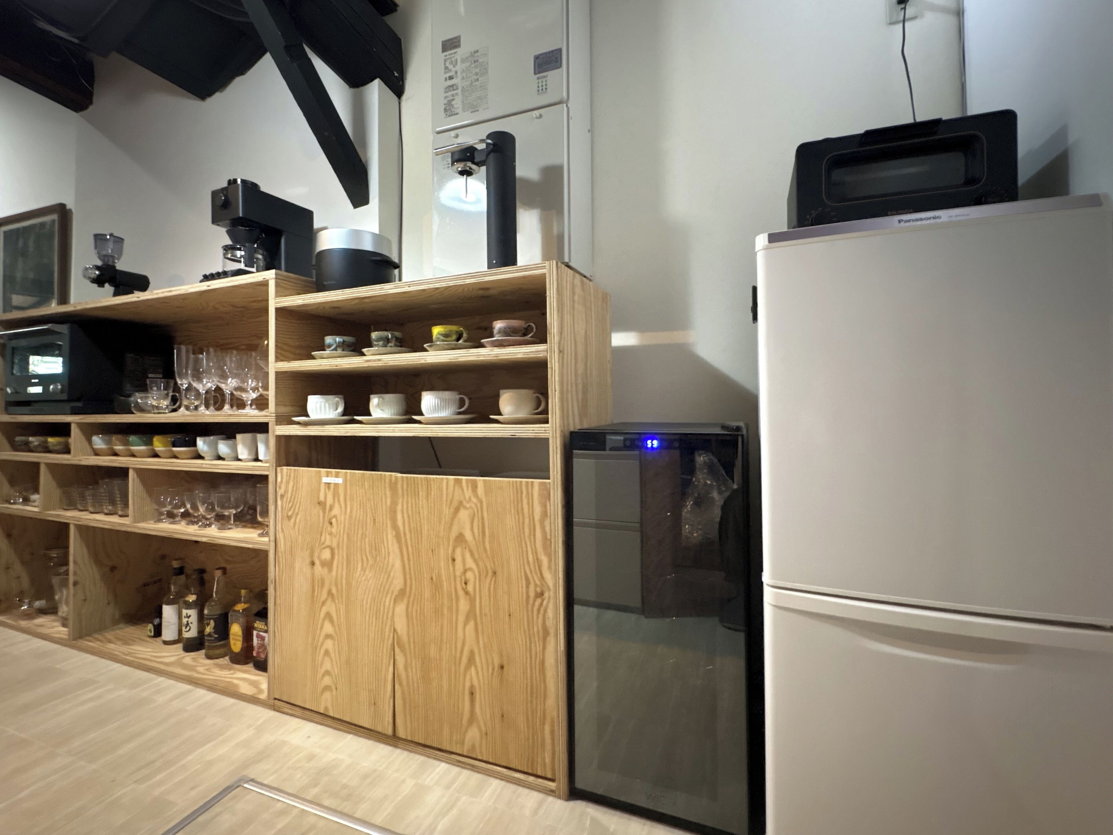 Eine Küche mit Holzausstattung, einem Kühlschrank, einer Mikrowelle und diversen Küchengeräten.