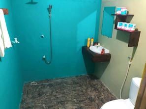 Un baño con ducha, lavamanos e inodoro.