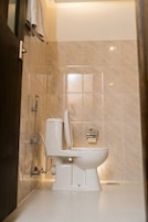Un baño moderno con inodoro, ducha y toallero.