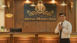 Una mesa de recepción de hotel con un letrero que dice 'Hotel Maden Inn'.