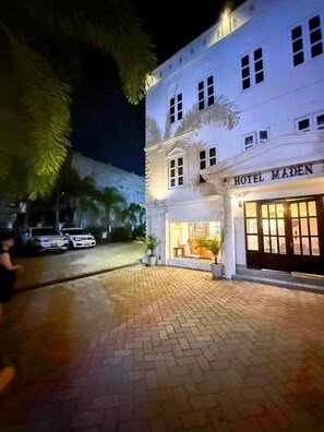 A hotel with a classic facade, a well-lit entrance, and a paved driveway. - Hotel Maden Inn (Itahari)