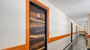 Hotellin käytävä, jossa on puiset ovet, joiden numerot ovat 305, ja marmorilattia.