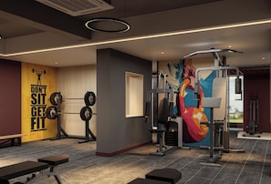 A gym with weightlifting equipment, a motivational poster, and a colorful mural. - The Inn Dhangadhi (Dhangadhi)